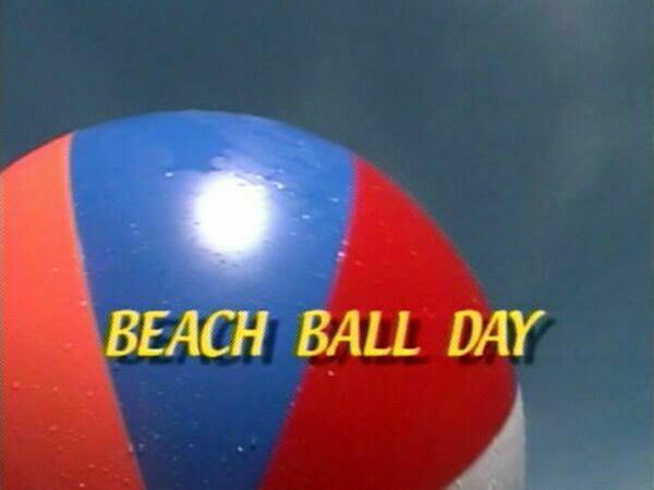 Nudists play a big ball on a beach